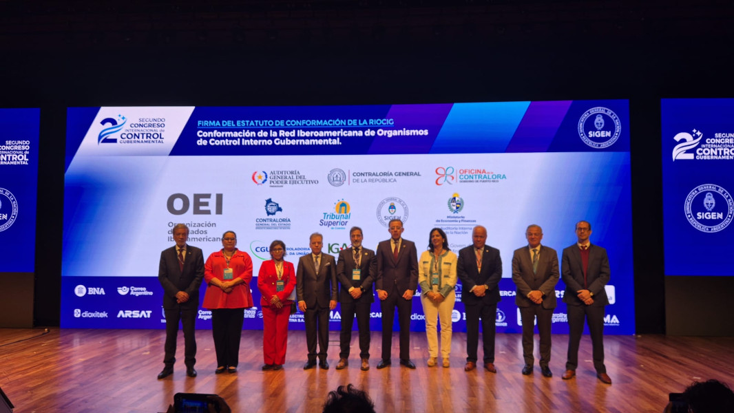 Dez oradores de pé no palco com o cartaz do congresso projetado ao fundo