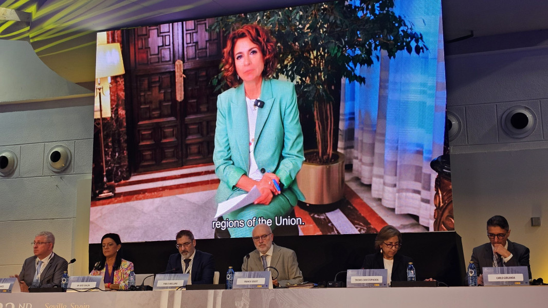 Painel de oradores à frente de uma imagem de outra oradora