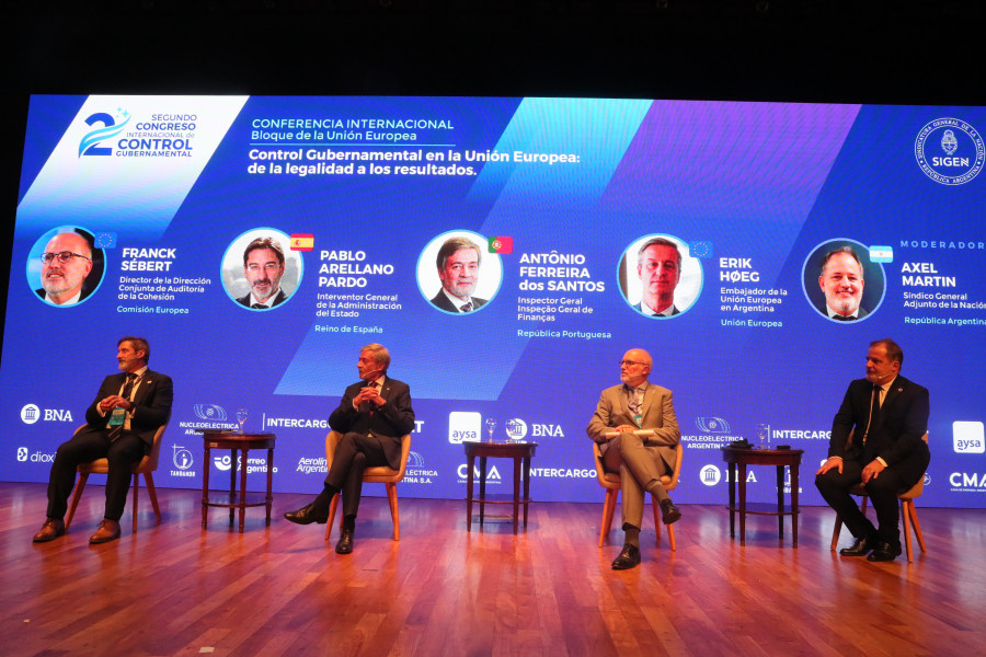 Painel de discussão com 4 oradores sentados no palco durante o congresso