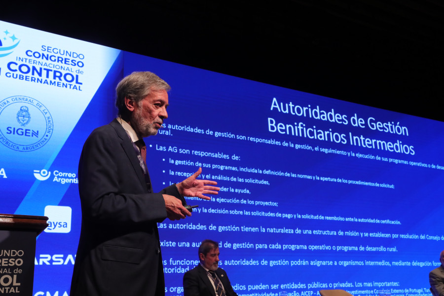 Perspetiva lateral do Inspetor-Geral no palco durante uma apresentação projetada no fundo da imagem