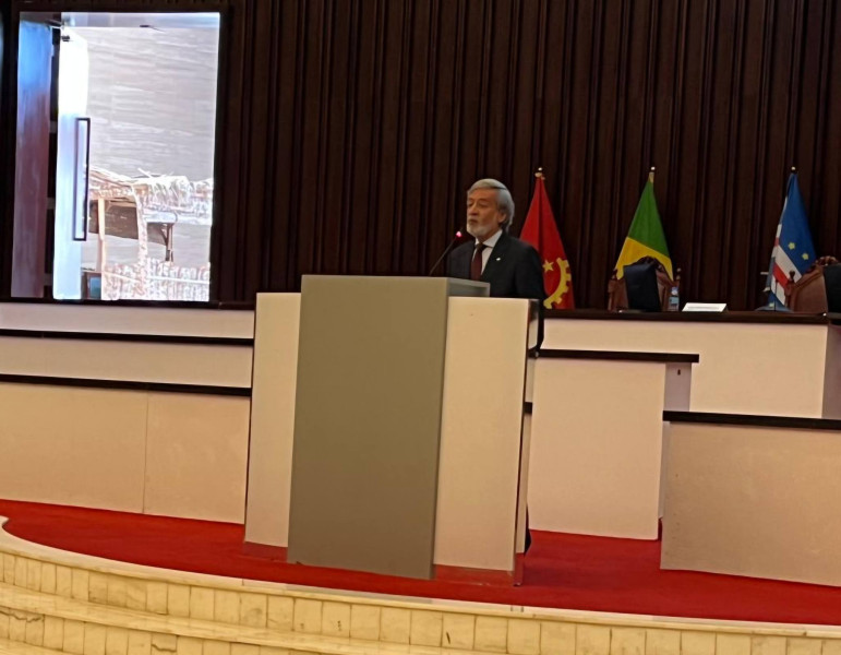 O Inspetor-Geral a discursar na conferência à frente de um púlpito com 3 bandeiras atrás de si