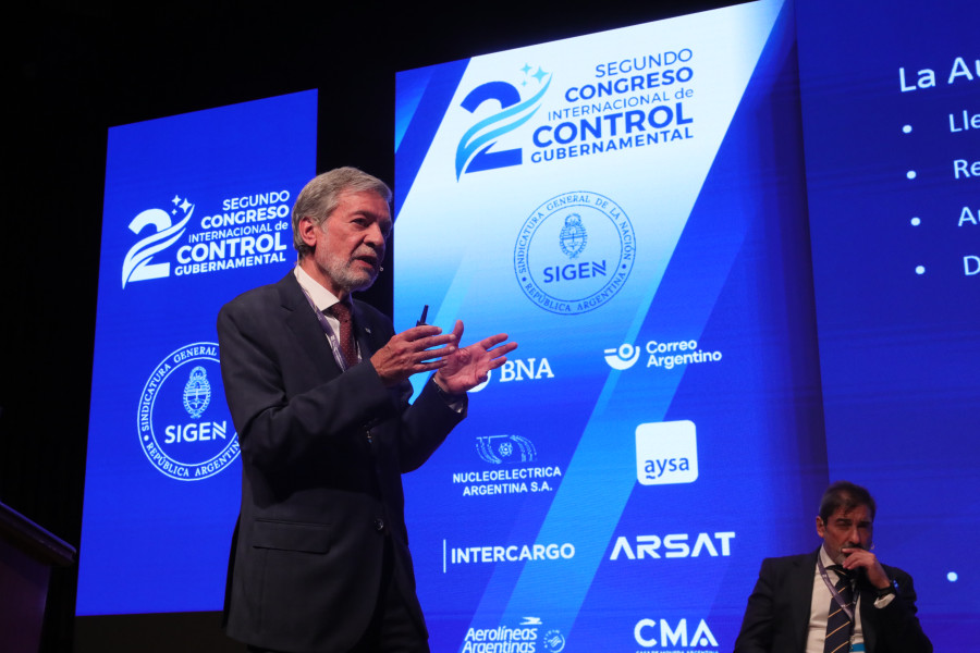 Inspetor-Geral a discursar à frente do cartaz do congresso