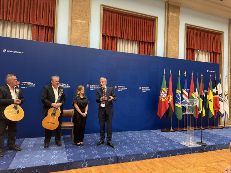 IG com três músicos dois dos quais com guitarras na mão num palco com as bandeiras de Portugal e dos países membros da CPLP.