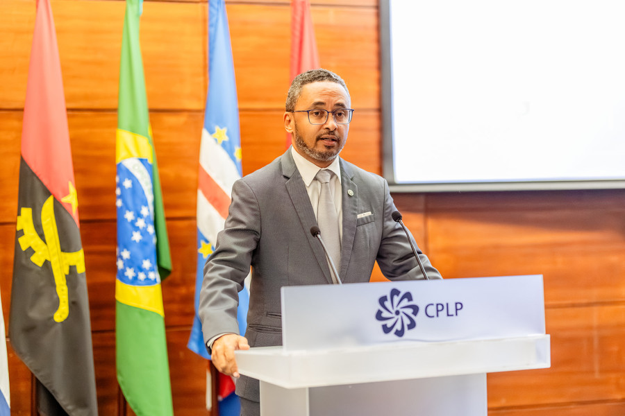 Orador atrás de um púlpito a discursar à frente de bandeiras dos países membros da CPLP.