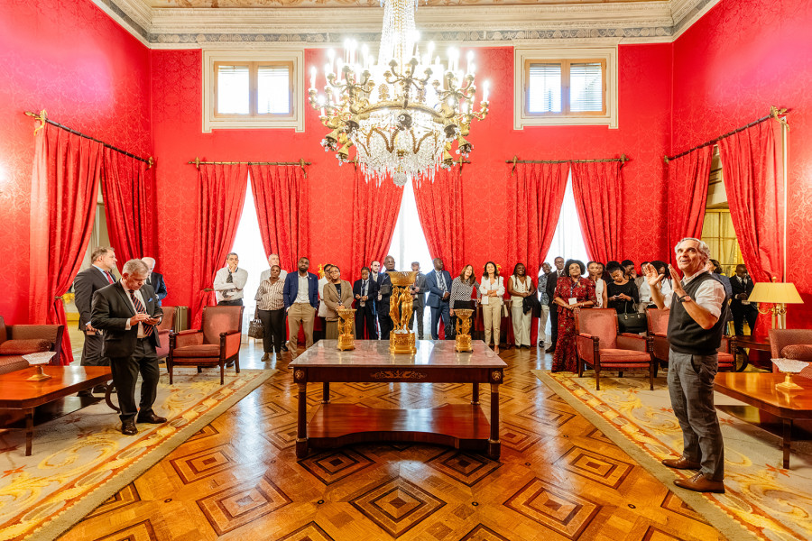 Grupo de pessoas durante uma visita guiada a um sumptuoso salão.