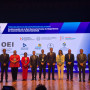 Dez oradores de pé no palco com o cartaz do congresso projetado ao fundo