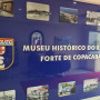 Parede de exposição no Museu Histórico do Exército e Forte de Copacabana com várias fotografias