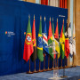 Bandeiras de Portugal e dos países membros da CPLP dispostas num palco.
