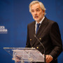 Orador atrás de um púlpito de acrílico transparente a discursar.