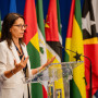 Subinspetora-Geral da IGF a discursar à frente das bandeiras dos países membros da CPLP.