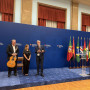 IG com três músicos dois dos quais com guitarras na mão num palco com as bandeiras de Portugal e dos países membros da CPLP.