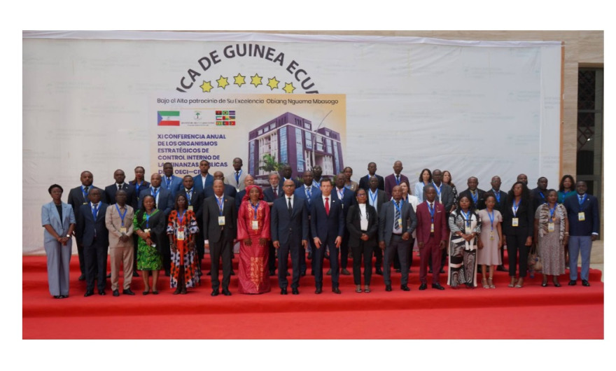 Foto de grupo dos participantes na Conferência posando em frente ao cartaz da conferência