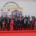Foto de grupo dos participantes na Conferência posando em frente ao cartaz da conferência